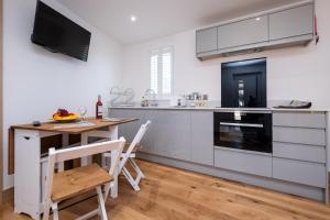a kitchen with a wooden table and a counter top at Weeping Willow – Three Tuns Apartments, Pettistree in Pettistree