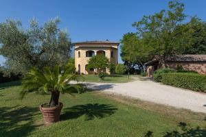 a large house with a palm tree in the yard at Poggio Vaccaio Casa Tramonto in Binami