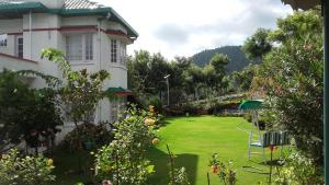 a yard of a house with a lawn with trees at Rosewood Estate in Chail