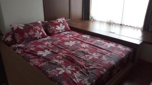 a bed with a red comforter in a room at Ruby Apartment #2 in Yogyakarta