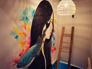 a painting of a woman on a wall at Way Shack Hostel in Oslob