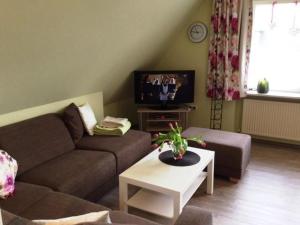 a living room with a couch and a tv at Haus Fabricius in Tating