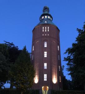 uma torre alta com luzes acesas à noite em Ystads Gamla Vattentorn em Ystad