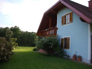 a blue house with a balcony and a yard at Casa Anna in Bad Gleichenberg