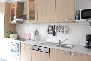 a kitchen with white cabinets and a sink at Strandgut-Tating in Tating +9 photos