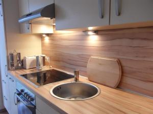 a kitchen with a sink and a wooden counter top at Ferienwohnung am Seezeichen in Böhl