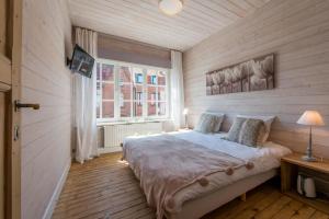 um quarto com uma cama grande num quarto com pisos em madeira em Maison Mariette em Nieuwpoort