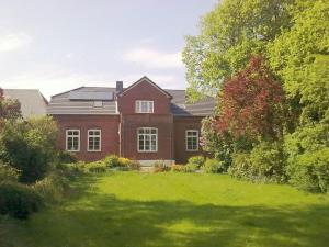 una casa de ladrillo rojo con un patio verde en Der Mithinghof, en Kotzenbüll