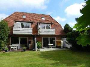 a house with a green lawn in front of it at Diekje Deel in Sankt Peter-Ording