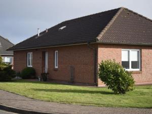 a red brick house with a black roof at Ferienhaus Strandgeflüster in Garding
