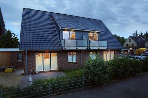 a house with a balcony on top of it at Ferienwohnungen Meeresgruss in Sankt Peter-Ording