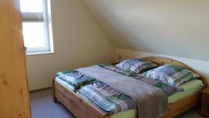 a bedroom with a bed with a wooden frame and a window at Ferienwohnungen Meeresgruss in Sankt Peter-Ording