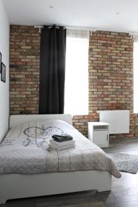 sypialnia z łóżkiem i ceglaną ścianą w obiekcie Stay99 Apart w Poznaniu