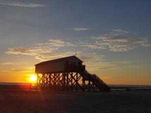 a lifeguard tower on the beach at sunset at Haus Kahlke in Sankt Peter-Ording