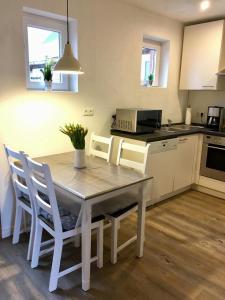 a kitchen with a table and chairs in a kitchen at Bauernhof Steffens in Tating