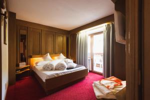 Un pat sau paturi într-o cameră la Hotel Catinaccio