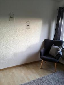 a chair in a room with two signs on the wall at Bauernhof Steffens in Tating