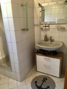 La salle de bains est pourvue d'un lavabo et d'un miroir. dans l'établissement Bauernhof Steffens, à Tating