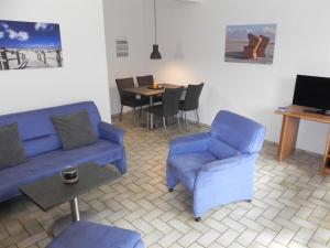 a living room with a blue couch and chairs and a table at Sandpeter 1 in Sankt Peter-Ording +19 photos