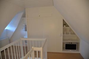 Zimmer mit einer Treppe, einem TV und einer Treppe in der Unterkunft Haus Wattläufer - Lütte Koje in Sankt Peter-Ording