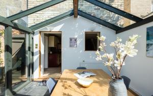 een eetkamer met een tafel en een glazen verlenging bij The Madras Cottage - Bright 3BDR Home with Garden in Cambridge