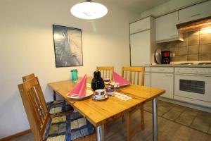 a kitchen with a wooden table with chairs and a tableablish at Ferienwohnung Remuß in Garding
