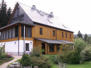 uma grande casa de madeira com um telhado de gambrel em Ferienwohnung Sternkopf em Breitenbrunn