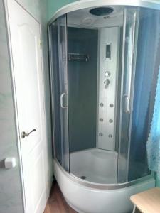 a shower with a glass door in a bathroom at Hotel Uyut in Bilhorod-Dnistrovsʼkyy