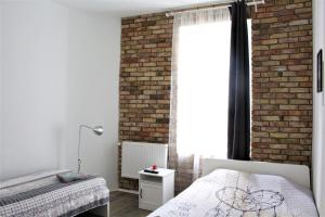 a bedroom with two beds and a brick wall at Stay99 Apart in Poznań