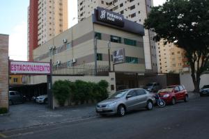 a car parked in front of a building at Pinheiros Hotel in Goiânia