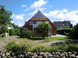 a red house with a gambrel roof at Ferienwohnung Stadtfelder in Böhl