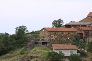 una casa de piedra al lado de una colina en Gite Chez Coste Gilles, en Saint-Privat-du-Dragon