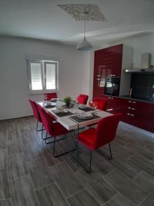 a dining room with a table and red chairs at Holiday House Ivan in Zemuniki