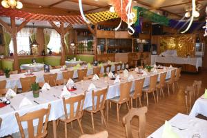une salle à manger avec des tables et des chaises blanches dans l'établissement Marschalls Hotel Am Rennsteig, à Neuhaus am Rennweg