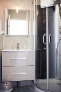 a bathroom with a sink and a shower at Sunrise Beach Hotel in Gruissan