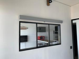 a window on a wall with a reflection of a room at LACANAU FRONT DE MER in Lacanau