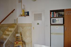 a kitchen with a refrigerator and a staircase with a microwave at Casa Peter Los Cristianos centro a 20 metros del mar in Los Cristianos