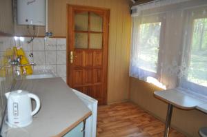 kuchnia ze zlewem i drewnianymi drzwiami w obiekcie Ośrodek Wypoczynkowy Warmia w mieście Butryny