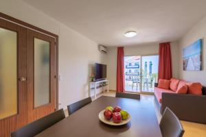 a living room with a table with a bowl of fruit on it at Rentalmar Pins Marina in Cambrils