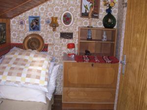 Agancs Vendégház في بالاتونزيم: غرفة نوم مع سرير وخزانة ورف