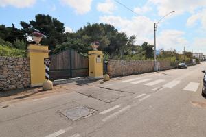 una calle con una valla y una puerta con flores en la parte superior en Dimora Relais Excelsa, en Gallipoli