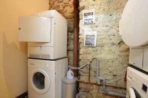 a washer and dryer in a room with a stone wall at RIBEAUVILLE city center - Gîte des Ménétriers, LE TOKAY - in Ribeauvillé