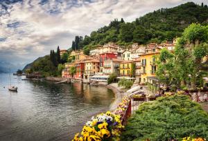 a group of buildings on the side of a river at Petit Bijou in Varenna