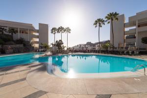 a large swimming pool in a resort with palm trees at Holiday Club Puerto Calma in Puerto Rico de Gran Canaria