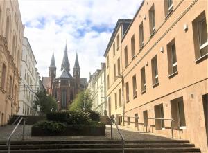 una calle de la ciudad con escaleras y una iglesia con torres en Schwerin Apartment am Pfaffenteich 1. Obergeschoss, en Schwerin