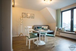 Un comedor con mesa y sillas en Szuflada Apartamenty, en Augustów