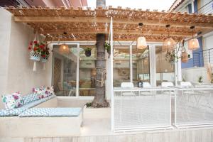 a patio with a bench and a table and chairs at Frini Hotel in Tolo