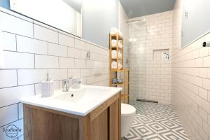 un baño con lavabo e inodoro en Szuflada Apartamenty, en Augustów 35 fotos más