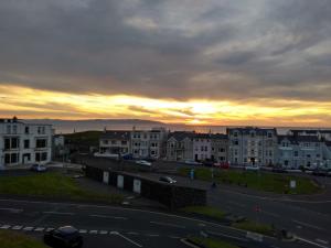 a sunset over a city with buildings and a street at The Loft Guest Apartment in Portstewart
