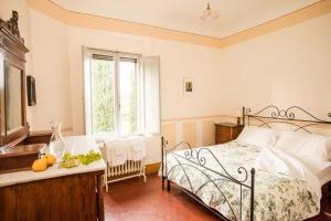 um quarto com uma cama, uma mesa e uma janela em Tenuta di Spannocchia em Rosia